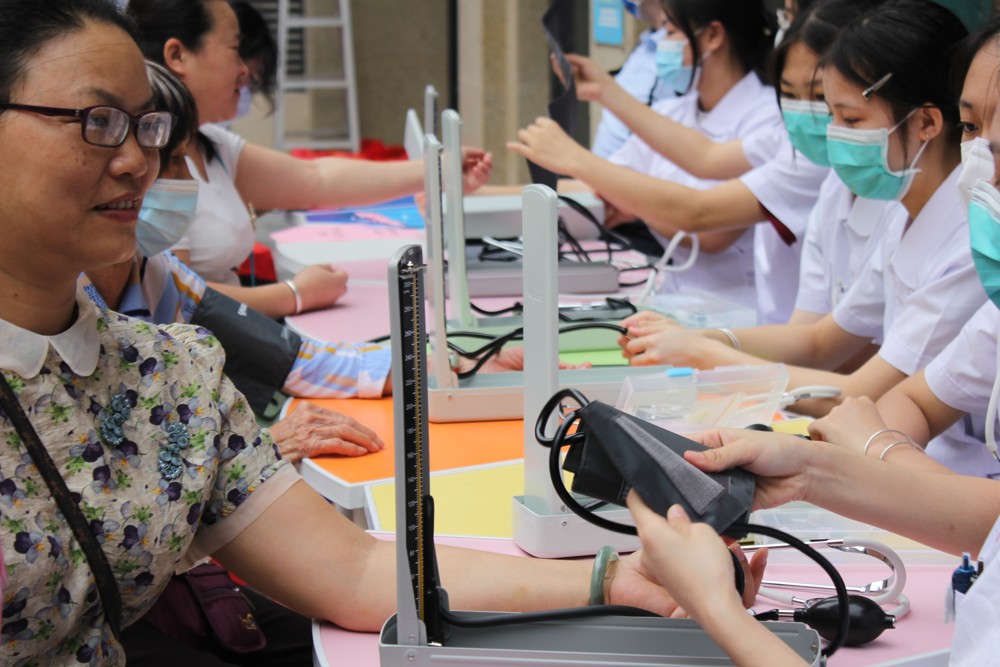 心理健康协会护理专业的学生在帮社区居民测量血压